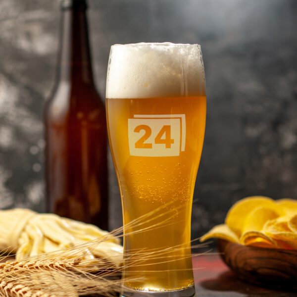 Weizenglas mit Gravur „24“, gefüllt mit Bier und Schaumkrone